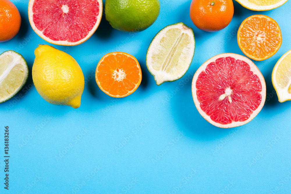 Several kinds of whole and cut citrus on a blue background Several kinds of whole and cut citrus on a blue background