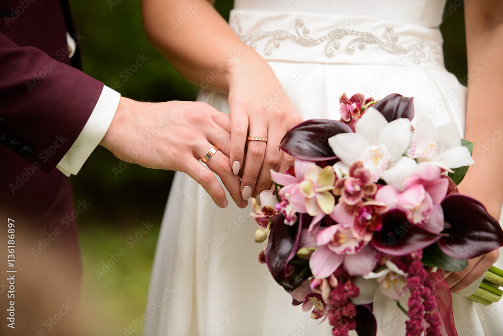 Closeup of groom placing ring on brides finger on their Closeup of groom placing ring on brides finger on their