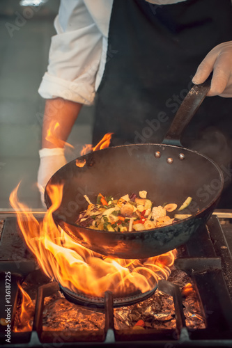 Canvas Print chef in hotel kitchen prepare vegetable food with fire