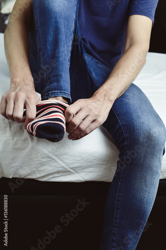 young man putting on or taking off his socks