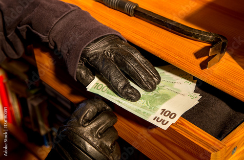 Geldscheine werden aus einer aufgebrochenen Möbelschublade gestohlen