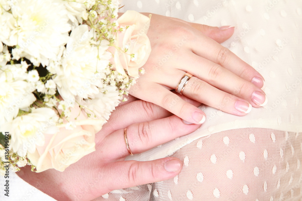 Rings on hands and bouquet