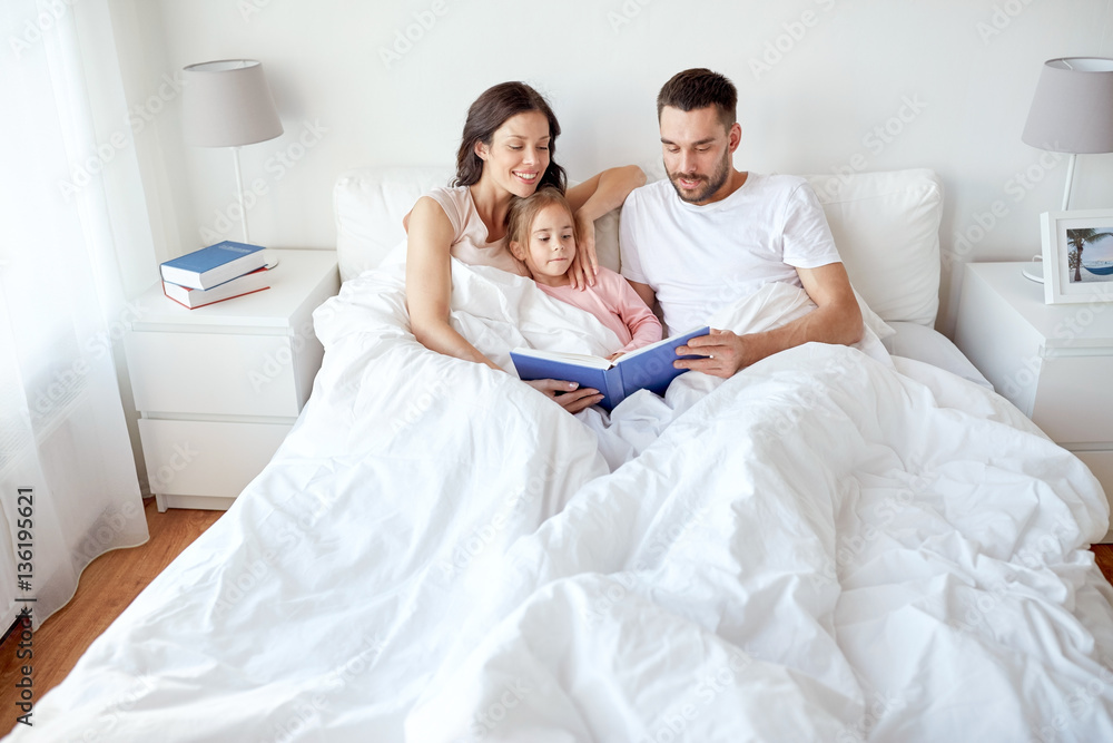 happy family reading book in bed at home happy family reading book in bed at home
