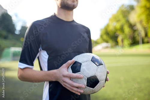 close up of soccer player with football on field