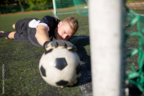 goalkeeper with ball at football goal on field