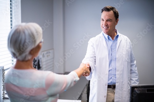 Doctor shaking hands with senior woman