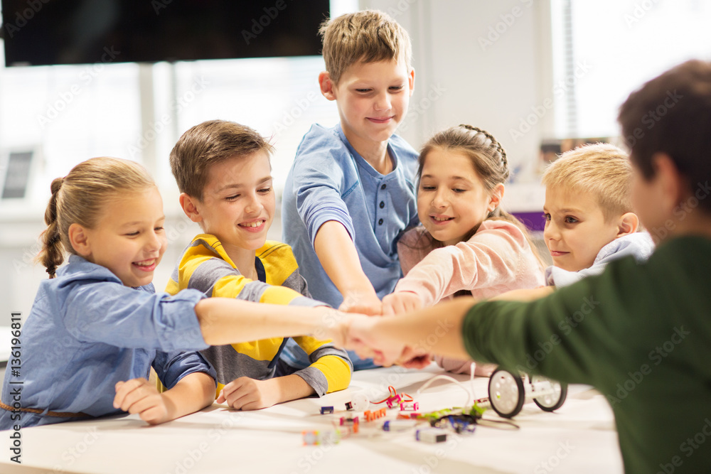 happy children making fist bump at robotics school happy children making fist bump at robotics school