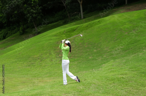 Women player golf swing shot on course in summer - Sports concept, greenery tone