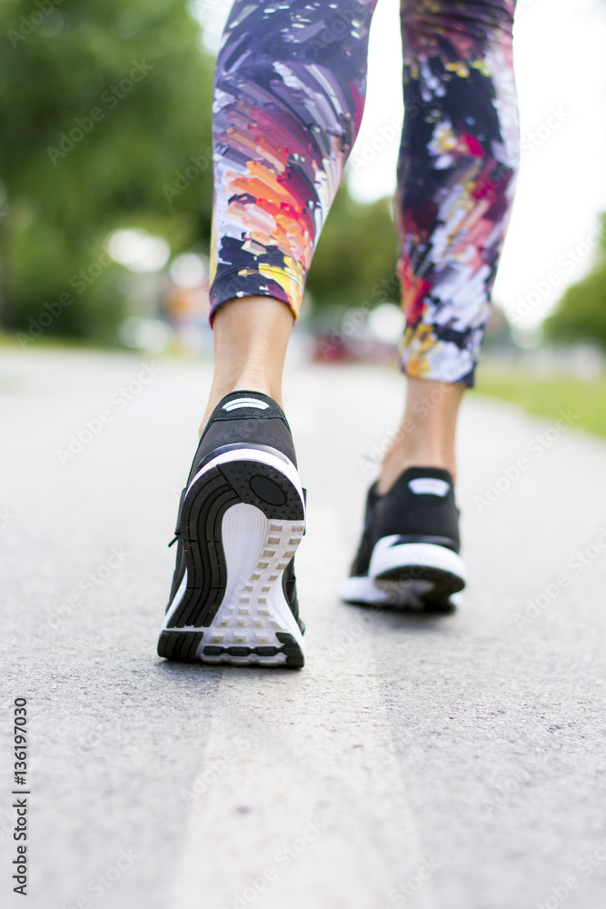 Woman with an athletic pair of shoes going for a jog or run Woman with an athletic pair of shoes going for a jog or run