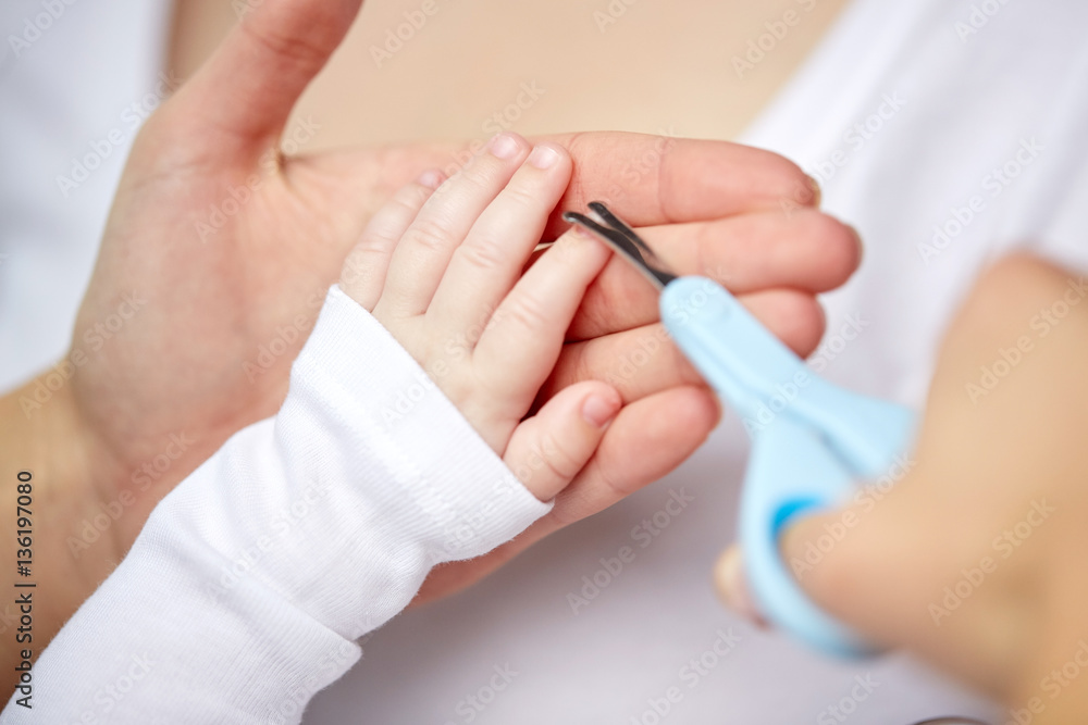 close up of hand with scissors trimming baby nails close up of hand with scissors trimming baby nails