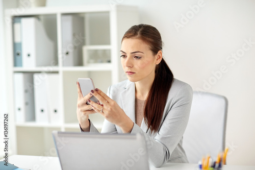 businesswoman with smartphone at office © Syda Productions
