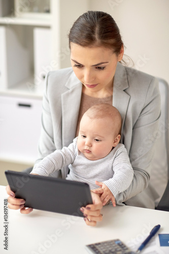 businesswoman with baby and tablet pc at office