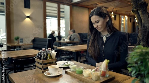Young woman getting stomach pain during meal in cafe
