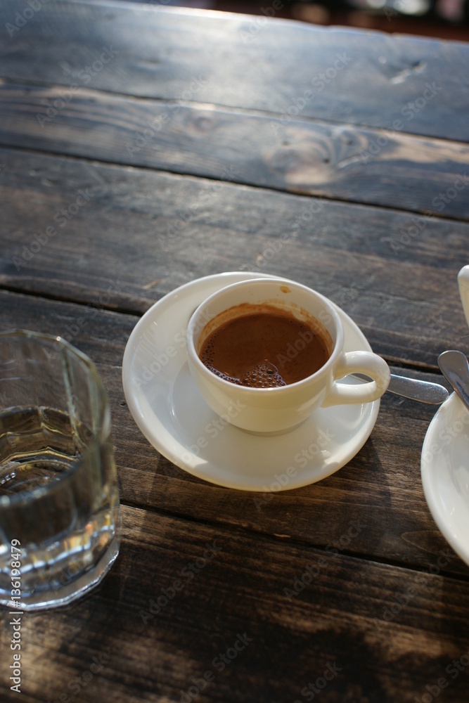 A cup of strong coffee on a table on a sunny day A cup of strong coffee on a table on a sunny day