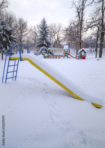 Children's playground covered with snow in winter photo