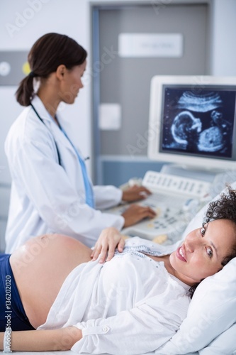 Doctor doing ultrasound scan for pregnant woman