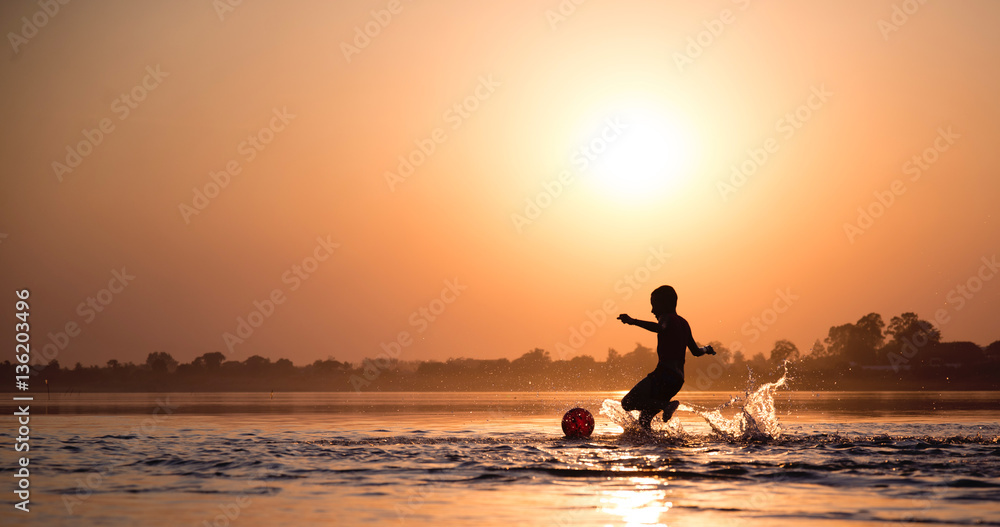 Silhouette of children playing in the river.