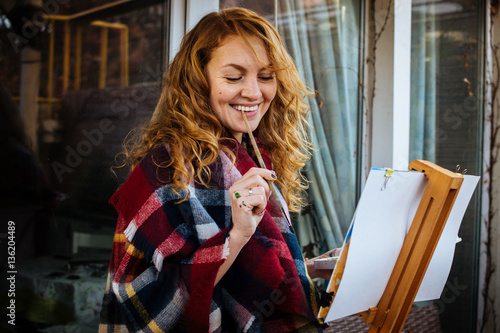 Foto Attractive woman smiling painting with watercolor at the easel