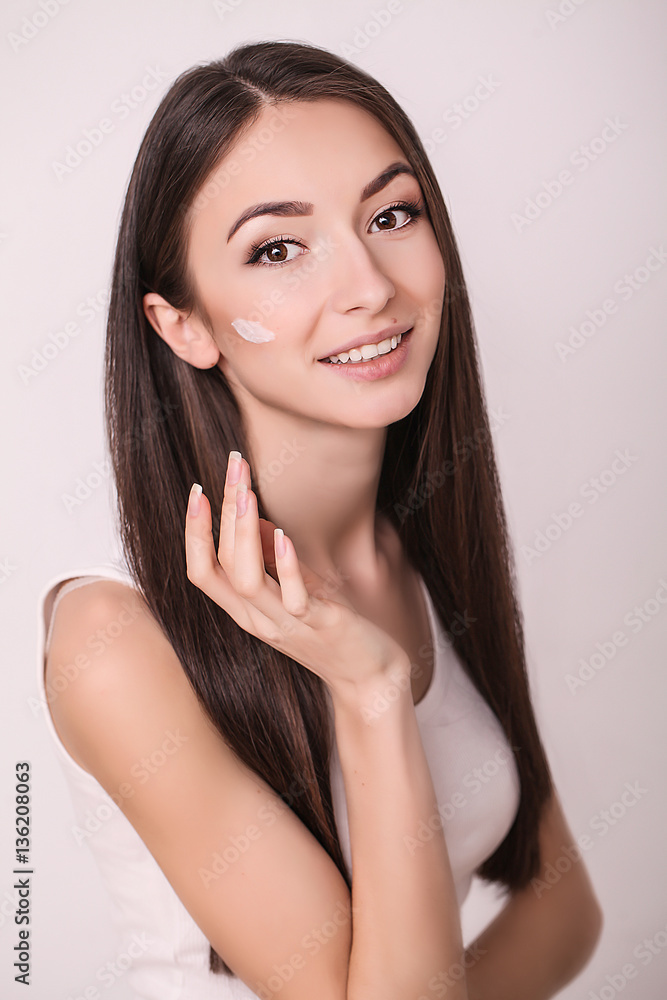 Applying cosmetic cream. A beautiful young woman applying face moisturizer. Scine care of the face and hands Applying cosmetic cream. A beautiful young woman applying face moisturizer. Scine care of the face and hands