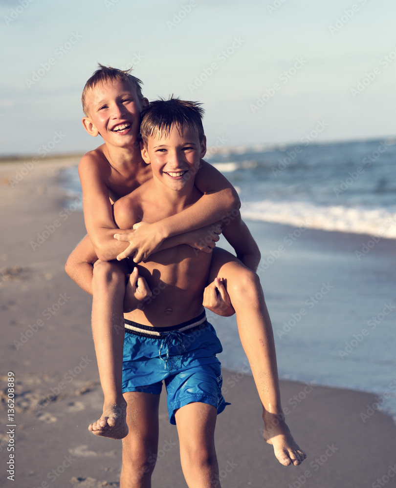 Portrait of two happy kids playing on the beach on summer vacat Portrait of two happy kids playing on the beach on summer vacat