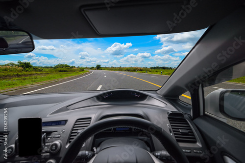 View from inside the car and drive a car on road with blue sky background, Sun light flare, Selective focus © sutthinon602