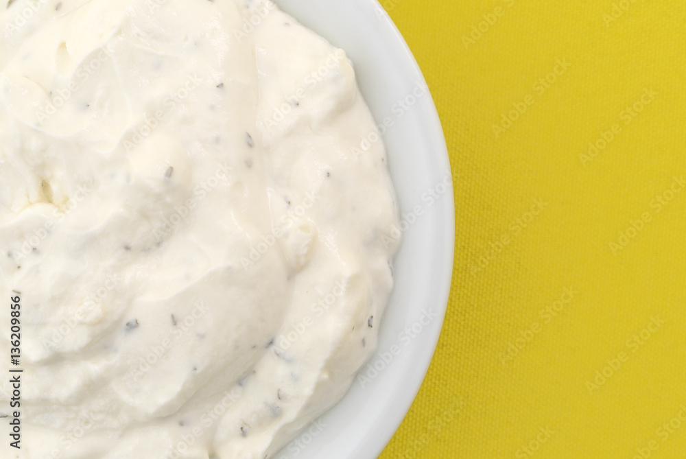 Top close view of a small bowl of French onion dip on yellow tablecloth. Top close view of a small bowl of French onion dip on yellow tablecloth.