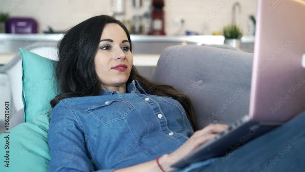 Young, pretty woman using laptop lying on sofa at home
Young, pretty woman using laptop lying on sofa at home