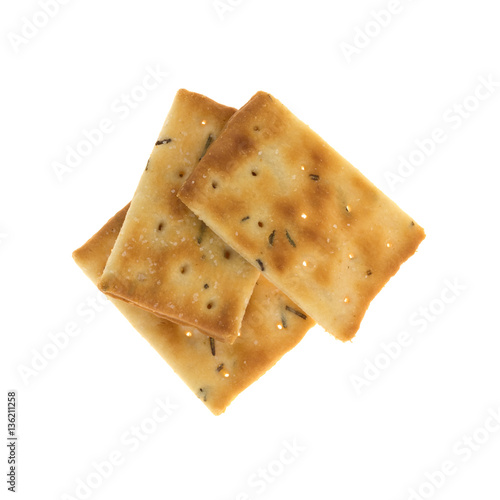 Top view of three seasoned rosemary and olive oil crackers isolated on a white background.