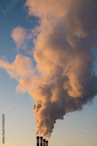 environmental pollution concept, pipes and smog on blue sky background