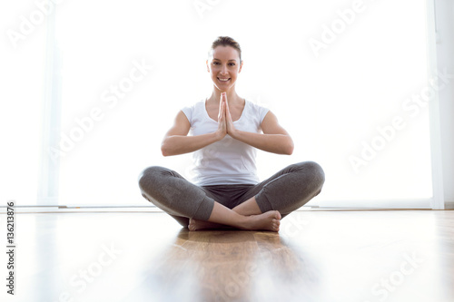 Beautiful young woman doing yoga exercises at home.