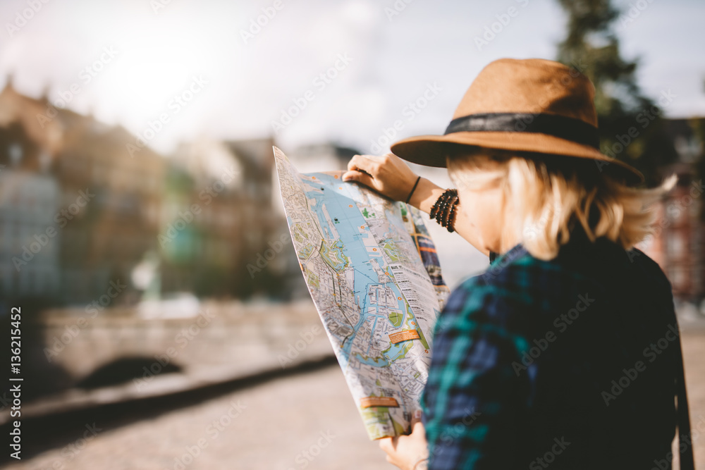 Young tourist woman searching right direction on map - obrazy, fototapety, plakaty 