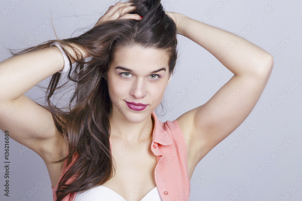 Sporty girl smiling on studio, with hair on wind, looking to the camera, with her hands on her head. Sporty girl smiling on studio, with hair on wind, looking to the camera, with her hands on her head.