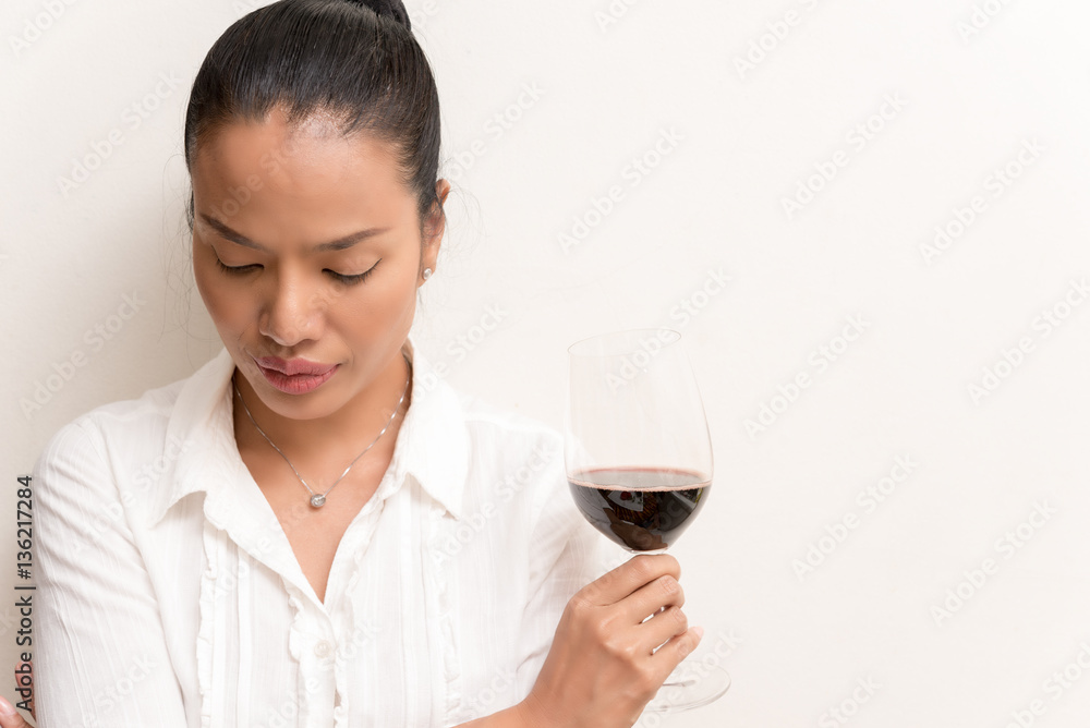 Businesswoman holding red wine glass over white background Businesswoman holding red wine glass over white background