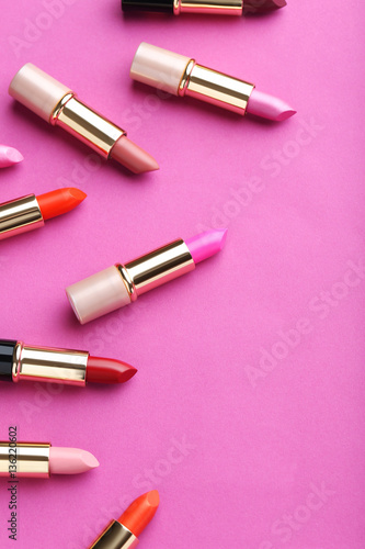 Colorful lipsticks on a pink background