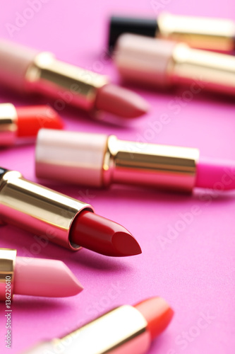 Colorful lipsticks on a pink background