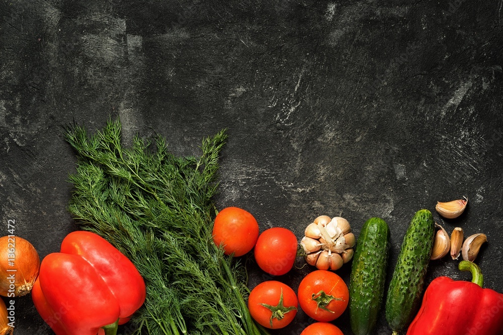 Raw vegetables on a dark black stone background, top view. Copy space for your text. Raw vegetables on a dark black stone background, top view. Copy space for your text.