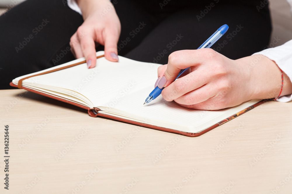 female hands with pen writing on notebook female hands with pen writing on notebook