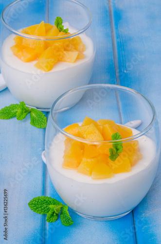 Bavarian cream mousse with vanilla and peaches in syrup in a glass