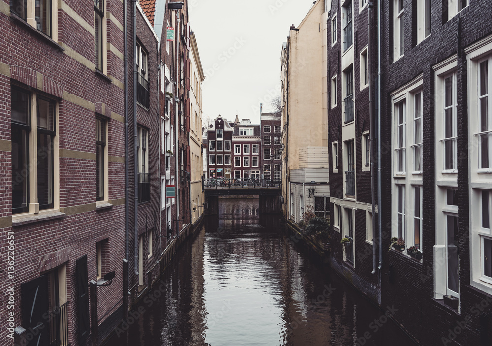 Canal between buildings in Amsterdam