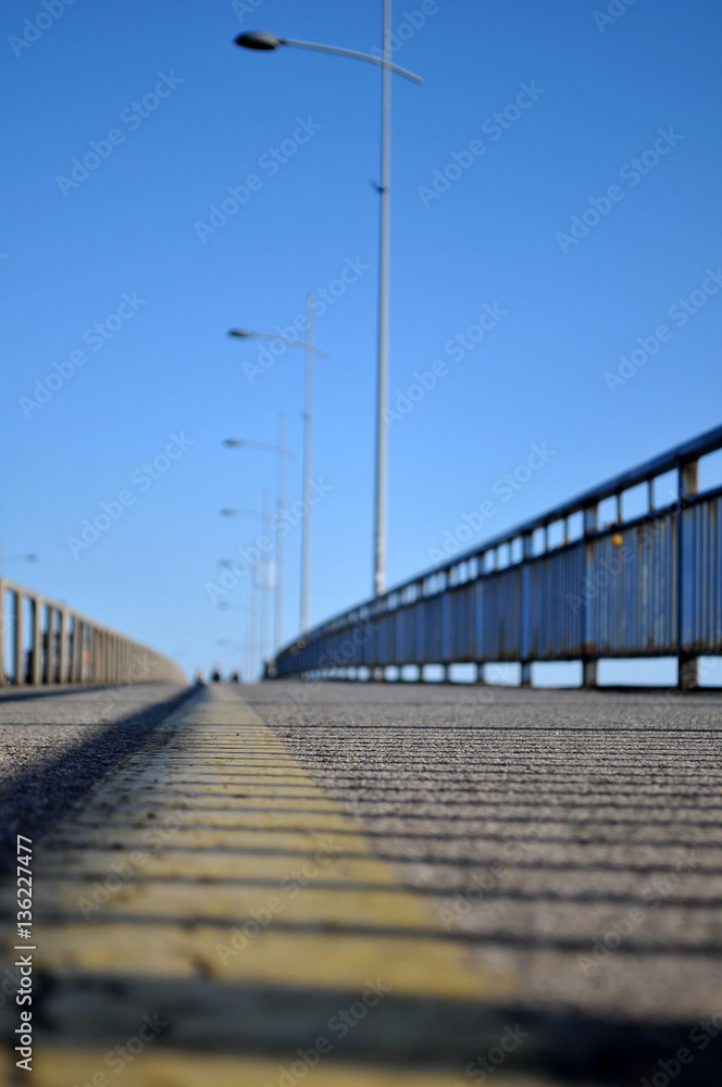 Photographed at the time of the sunset with the reflection of a fence on the bridge Varadin of yellow tape on the sidewalk above the Danube River in Novi Sad, Serbia