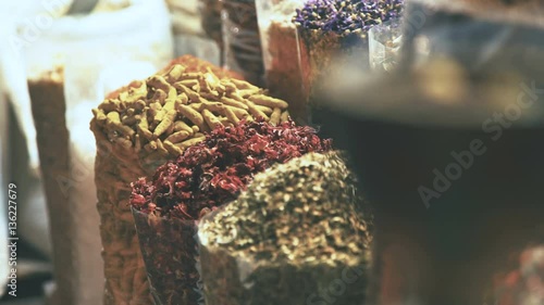 Eastern Market with spices in Emirates. Hibiscus, curry, turmeric. Colourful and fragrant spices. The merchant market. Shop owner at spice market arranges display