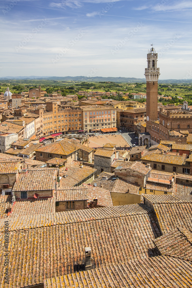 view to tower and teracotta roofs in Italian city