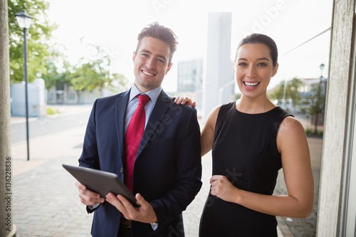 Businessman and colleague holding digital tablet 