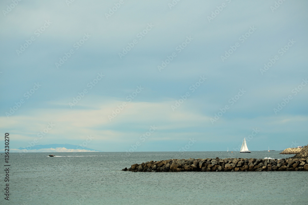 Beautiful sailing and motor boats float in calm blue sea