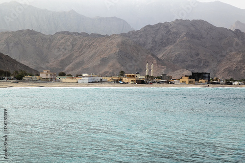 View on a empty beach in Oman with mosque and traditional arabic photo