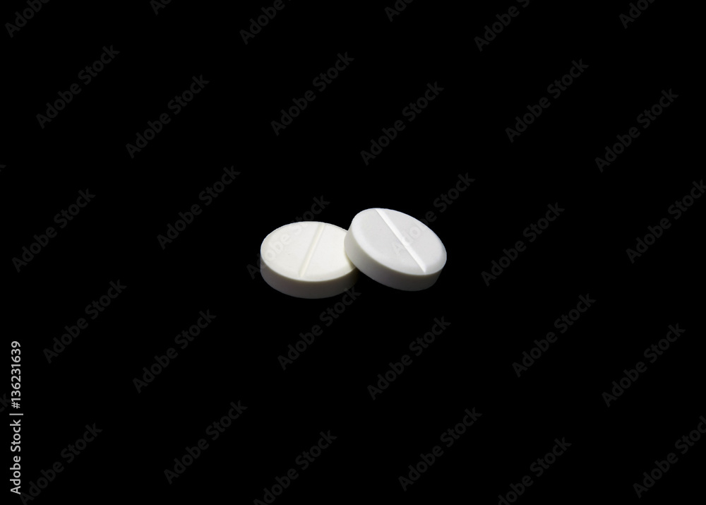Composition of the two white round pills isolated on black background Composition of the two white round pills isolated on black background