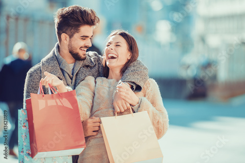 Beautiful young loving couple carrying shopping bags photo