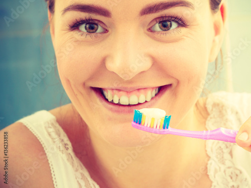 woman brushing cleaning teeth. Girl with toothbrush in bathroom.