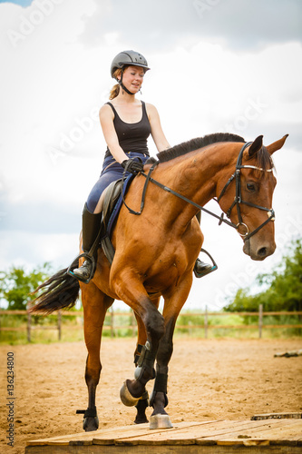 Jockey girl doing horse riding on countryside meadow © Voyagerix