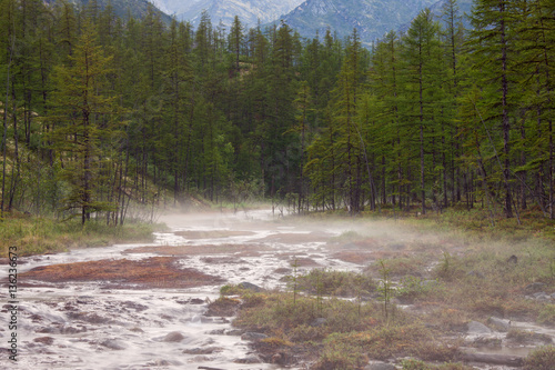 Light fog over the rocky creek in the mountains. The influx of the Indigirka River. Yakutia. Russia.